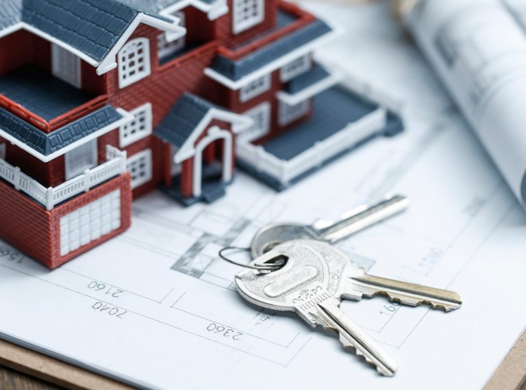 Villa house model, key and drawing on retro desktop (real estate sale concept)